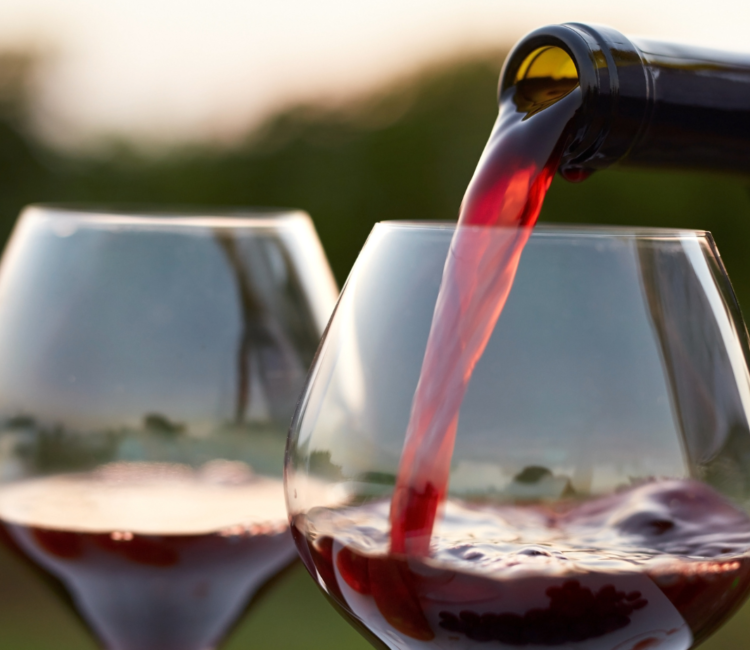 2 glasses of red wine being poured