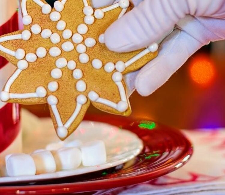 Cookies being put on a plate with mini marshmallows